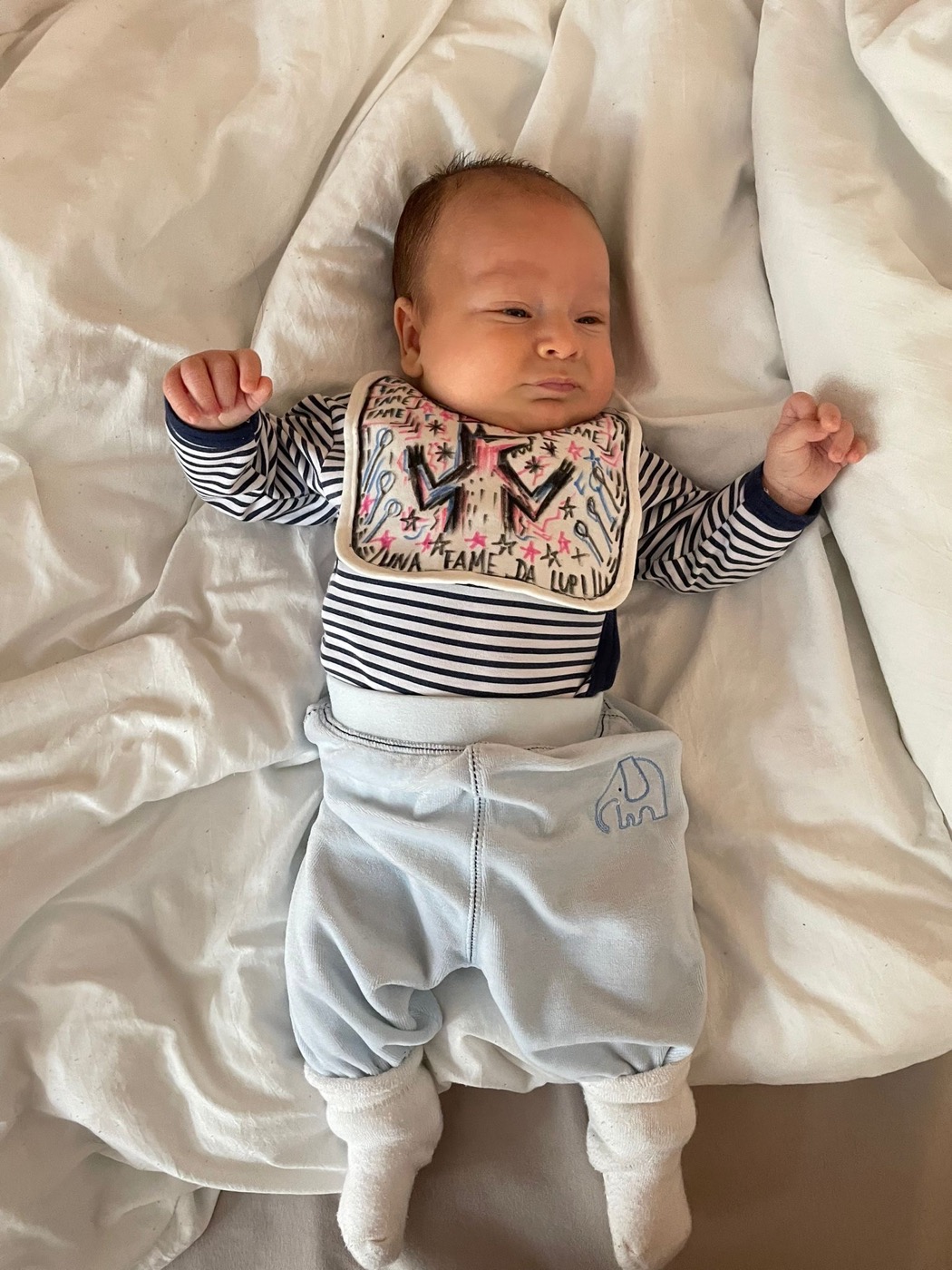 Babyfoto auf einem weißen Bett